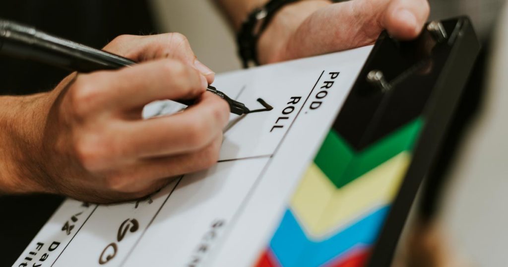 Video production member writing on clapper board